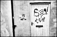 a black and white photo of a door with graffiti on it