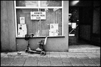 a black and white photo of a scooter in front of a building