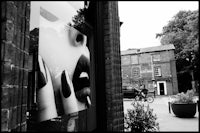 a black and white photograph of a woman's face in a shop window
